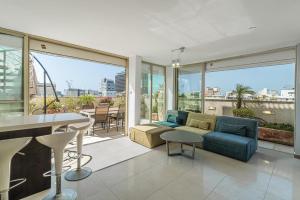 uma sala de estar com um sofá e uma mesa em Penthouse 3BR in Ben Yehuda By Holiday Rentals em Tel Aviv
