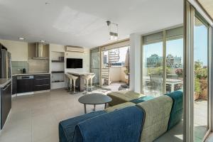 uma sala de estar com um sofá e uma cozinha em Penthouse 3BR in Ben Yehuda By Holiday Rentals em Tel Aviv