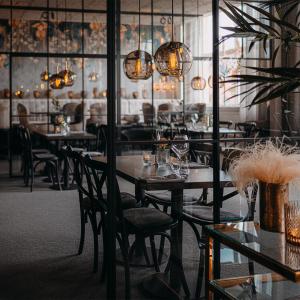 un comedor con mesas, sillas y luces en Sunlight Hotel Conference & Spa en Nyköping