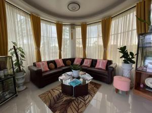uma sala de estar com um sofá e uma mesa em Pilot Hotel powered by Cocotel em Alaminos