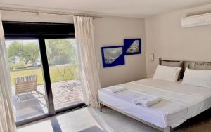 a bedroom with a bed and a sliding glass door at Olivia Estate Villa with Private Swimming Pool in Elia