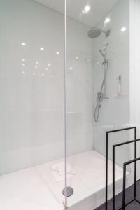 eine Dusche mit weißen Wänden und einer Glastür in der Unterkunft Large Luxury Residence Near Townhall & Votivkirche in Wien