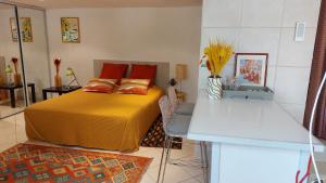 - une chambre avec un lit jaune et une table dans l'établissement studio indépendant près du centre ville, à Nîmes