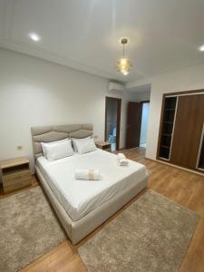 1 dormitorio con 1 cama blanca grande con alfombra en Charmant Appartement au Cœur de la Ville en Marrakech