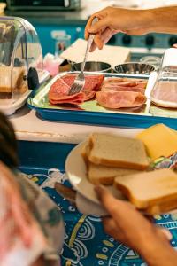 a person holding a fork and a plate of food at The Flying Pig Beach Hostel, ages 18 - 40 in Noordwijk aan Zee