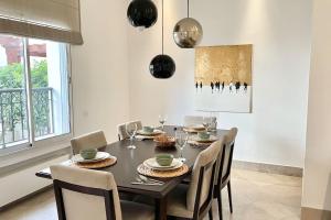 a dining room with a black table and chairs at Sindbad House in La Marsa