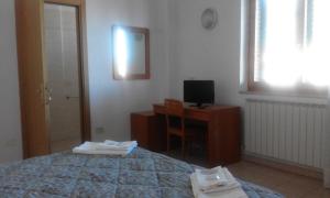 a bedroom with a bed and a desk with a television at Osteria dei Locandieri in Abbadia San Salvatore