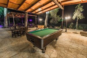 a pool table on a patio at night at Pine View Hotel (Okella) in Saittas
