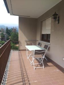 a table and chairs on a patio with a balcony at Dream Baveno 2 in Baveno