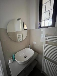 La salle de bains est pourvue d'un lavabo blanc et d'un miroir. dans l'établissement Dream Baveno 2, à Baveno