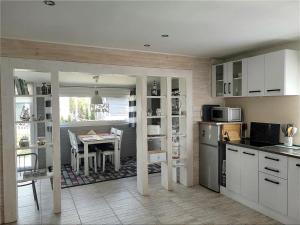 a kitchen with white cabinets and a dining room with a table at Wolnostojący dom na dużym prywatnym terenie -pet friendly- in Lubin