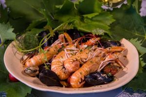a plate of shrimp and other vegetables on a table at Room`s Brica in Barbat na Rabu