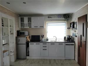 a kitchen with white cabinets and a sink and a window at Wolnostojący dom na dużym prywatnym terenie -pet friendly- in Lubin +8 photos