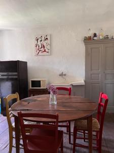 uma cozinha com uma mesa de madeira com cadeiras vermelhas e uma mesa de sidx em Gite casa mea em Santa-Lucia-di-Mercurio