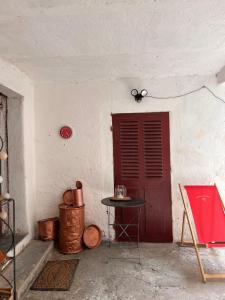 ein weißes Zimmer mit einer roten Tür und einem Tisch in der Unterkunft Gite casa mea in Santa-Lucia-di-Mercurio