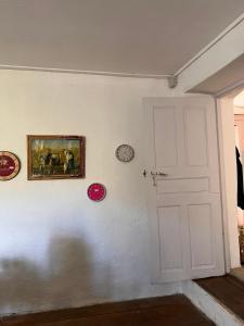 eine weiße Tür in einem Zimmer mit Uhren an der Wand in der Unterkunft Gite casa mea in Santa-Lucia-di-Mercurio