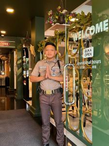Facet stoi przed sklepem. w obiekcie Bangreng Inn Hotel w mieście Bandung