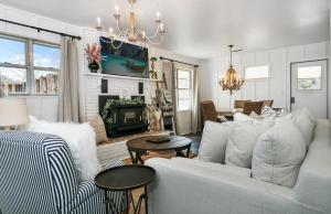uma sala de estar com um sofá branco e uma lareira em Hermes Ranch House with Hot Tub - 4 mi to Fred em Fredericksburg