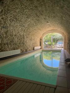 une piscine intérieure avec un mur en briques et une fenêtre dans l'établissement Appartement avec accès piscine et jardin dans hôtel particulier, à Nérac