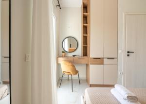 Schlafzimmer mit einem Schreibtisch, einem Spiegel und einem Stuhl in der Unterkunft Villenia Luxury Apartments in Kissamos