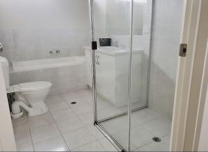 a white bathroom with a shower and a toilet at The Elands in Northfield