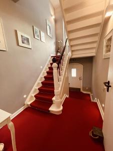 - un escalier de moquette rouge dans une maison dotée d'un tapis rouge dans l'établissement Boutique Hotel & Location Cham, à Meerbusch