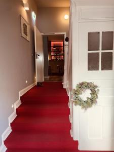 escalera con alfombra roja y puerta en Boutique Hotel & Location Cham, en Meerbusch