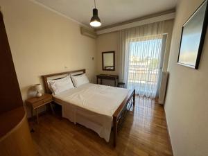 a bedroom with a bed and a large window at City View Apartment in Mytilini
