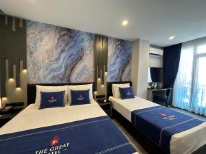 a hotel room with two beds and a mural on the wall at The Great Airport Hotel in Arnavutköy