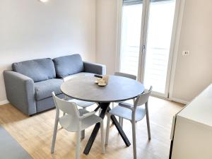 a living room with a table and chairs and a couch at Rho Mind Fiera House in Rho