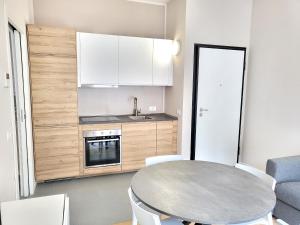 a kitchen with a table and white cabinets and a sink at Rho Mind Fiera House in Rho