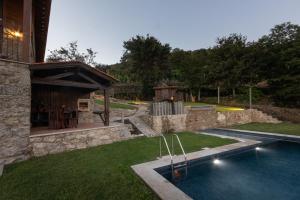 a backyard with a swimming pool and a house at HUGS Nature Retreat Heated Pool & Jacuzzi in Vila Verde