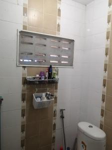 a bathroom with a toilet and a shelf on the wall at COZY HOUSE Working Space Stay with local in Bangkok Airport in Bangna
