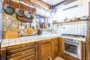 a kitchen with wooden cabinets and pots and pans on the wall at Stone House Srida in Baška Voda