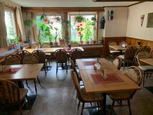 a restaurant with wooden tables and chairs and windows at Gasthaus Waldhorn in Bad Teinach-Zavelstein