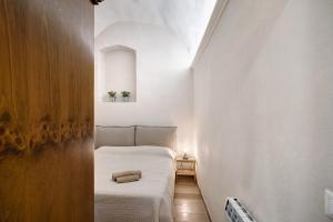 a small bedroom with a bed in a white room at Casa Elena in Bordighera