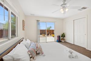 Un dormitorio blanco con una cama grande y una ventana en Cassia Tree, en Twentynine Palms