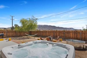 a hot tub in a backyard with a fence at Cassia Tree in Twentynine Palms