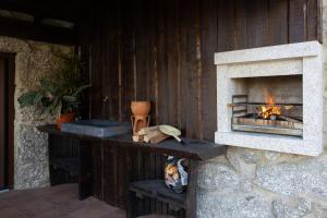 a fireplace with a stone counter with a fire place at Abraços dos Avós - Casas do Monte in Vila Verde