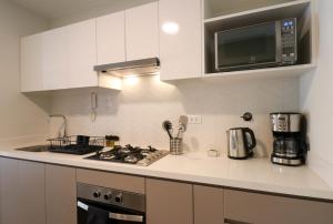 a kitchen with a stove and a microwave at La Mar Miraflores by Wynwood House in Lima