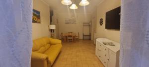 een woonkamer met een gele bank en een tafel bij L' appartamento dista 2 minuti a piedi dal mare! in Scalea