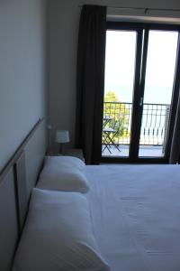 2 letti in una camera con balcone di Like Lake Bisentina a Marta