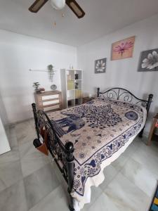 Schlafzimmer mit einem Bett mit einer blauen und weißen Bettdecke in der Unterkunft Quilla Apartment in Torrequebrada