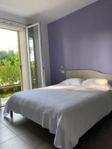 a bedroom with a large bed with a purple wall at Villa Athena Charme in Manerba del Garda