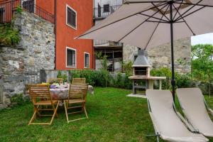 una mesa y sillas con una sombrilla en un patio en La casa di Leo, en Riccò del Golfo di Spezia