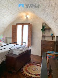 a bedroom with a bed and a window and a table at Terratetto Locorotondo Sweet Guest House in Locorotondo