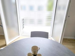 a table with a cup and two chairs in a room at Rho Mind Fiera House in Rho