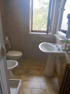 un bagno con lavandino, water e finestra di Albergo Grumentum a Grumento Nova Altre 16 foto