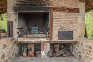 una chimenea de piedra con estufa. en caserio vasco con piscina y barbacoa en Murueta-Orozko