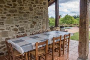 una mesa y sillas en un patio con una pared de piedra en caserio vasco con piscina y barbacoa, en Murueta-Orozko